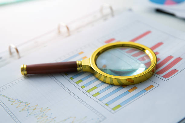 istock business audit - magnifying glass on financial graph report 939985422