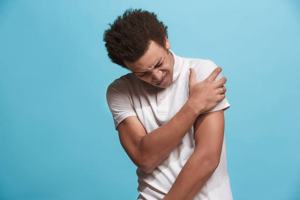 istock Young man overwhelmed with a pain in the shoulder 939986340