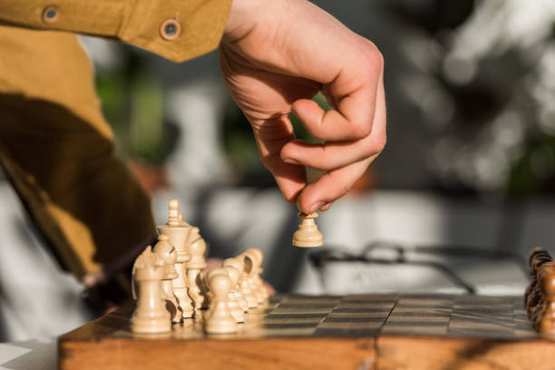 istock cropped shot of man making move while playing chess 939990596