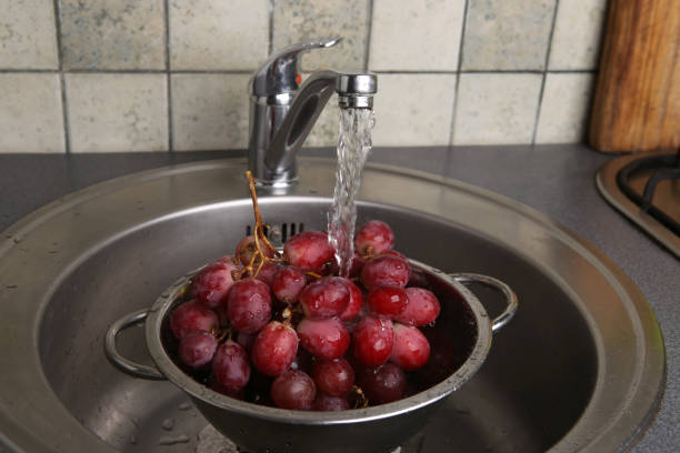 istock Washing fresh grapes in colander under the tap. 939997746