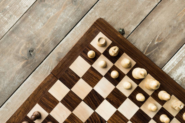istock Cropped view of chess baord with chess pieces on rustic wooden surface 939997770