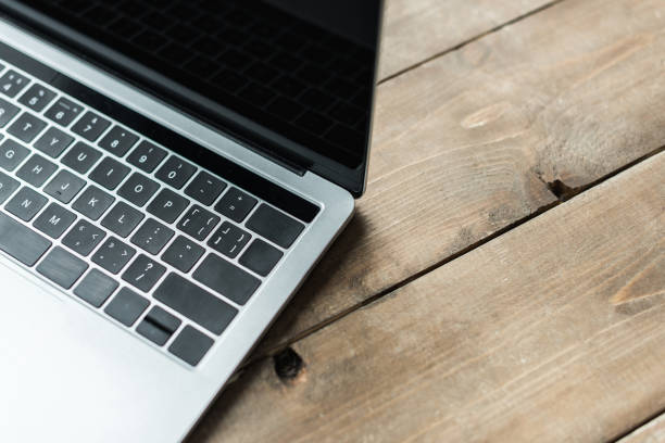 istock Cropped view of laptop on rustic wooden surface 939997992