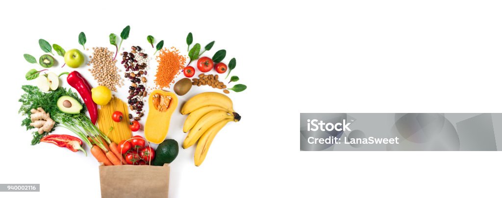 Healthy food background. Healthy vegetarian food in paper bag pasta, vegetables and fruits on white. Shopping food concept. Long format with copy space Supermarket Stock Photo