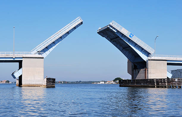 blue and steel drawbridge opening from on water perspective - ophaalbrug stockfoto's en -beelden
