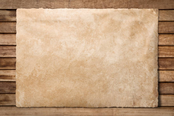 Old paper sheet at wooden background stock photo