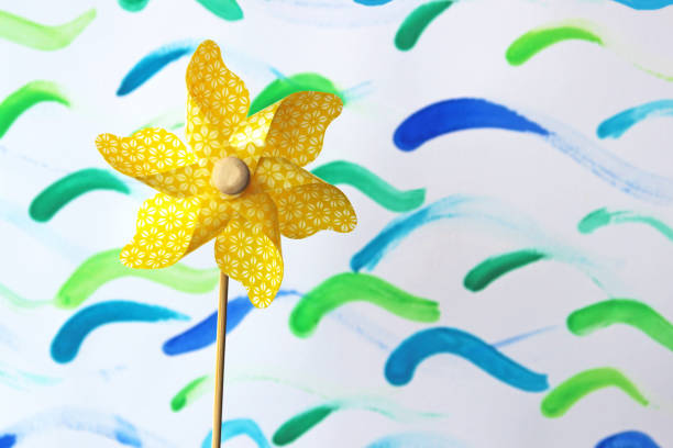 istock yellow pinwheel, painted waves in the back 940012126