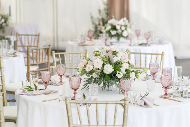 Beautiful table setting with crockery and flowers for a party, wedding reception or other festive event. Glassware and cutlery for catered event dinner. Beautiful table setting with crockery and flowers for a party, wedding reception or other festive event. Glassware and cutlery for catered event dinner wedding feast stock pictures, royalty-free photos & images