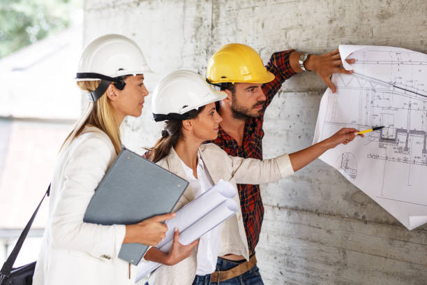 istock Team of inspectors and architects discuss about blueprints on construction site. 940018958