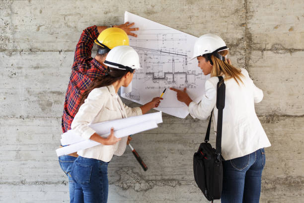 istock Team of inspectors and architects discuss about blueprints on construction site. 940018996