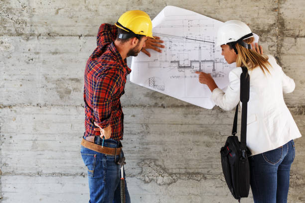 istock Team of inspectors and architects discuss about blueprints on construction site. 940019002