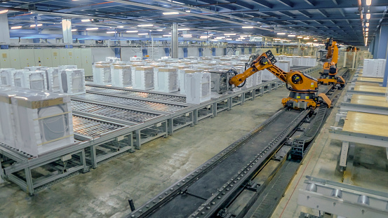 Robotic arms working on production line of appliance manufacturing factory.