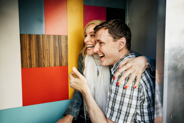 A tourist couple smiling and embracing while using a photo booth together.