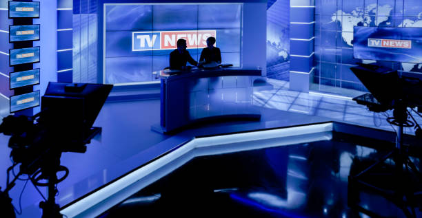Newsreaders in television studio Silhouetted of newsreaders in press room. newsreader stock pictures, royalty-free photos & images
