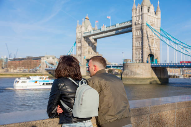 istock Smiling couple standing against tower bridge london 940046330