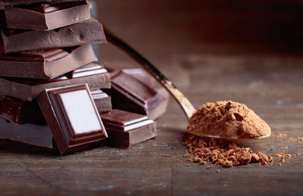 istock Broken  chocolate pieces and cocoa powder . 940054598