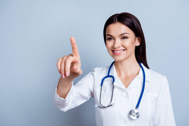 istock Professional successful smiling doctor touching invisiable surface with her finger 940066120
