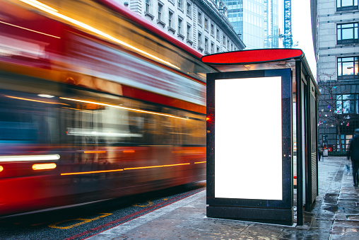 A blank billboard at a bus station at night