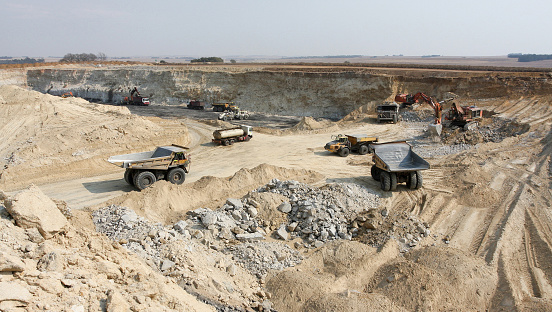 Large Rock Dump Trucks and Excavators digging and hauling in an open pit coal mine in South Africa