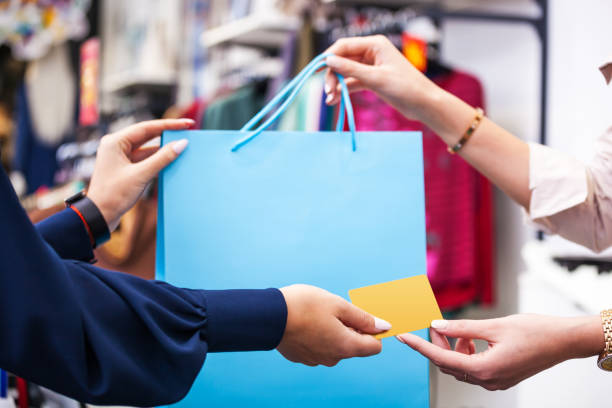 hands with shopping bag and credit card close up. - clothing store paying cashier credit card imagens e fotografias de stock