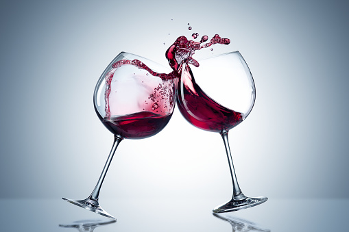 Two Empty wine glasses isolated on red background.
