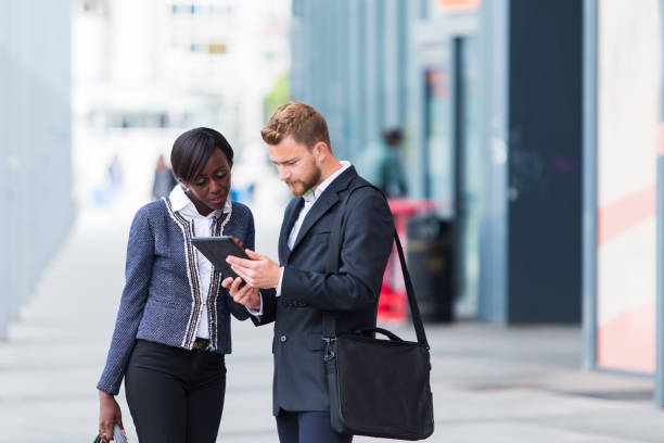 istock Business couple talking on a street a street....using digital tablet 940079122