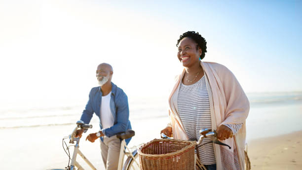 ce qui est vie si ne pas vécu au maximum ? - senior couple cycling beach bicycle photos et images de collection