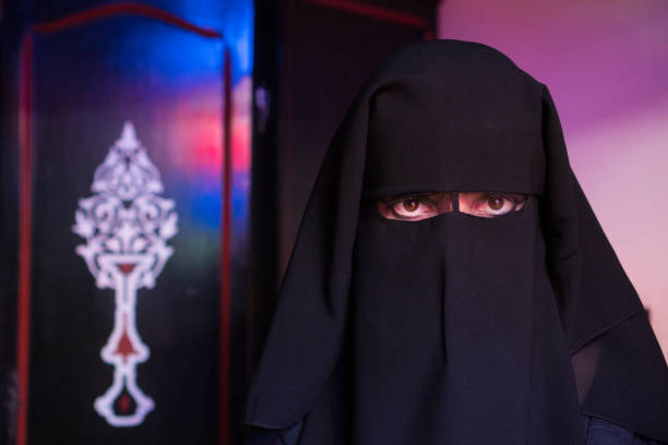 istock Arab woman with face covered with black niqab 940090378