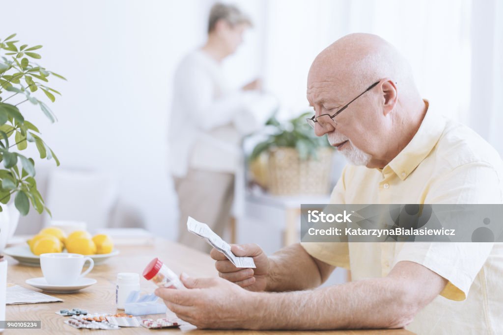 Homme lisant la prescription de son médicament - Photo de Médicament libre de droits