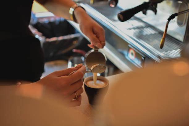 istock Hands of unrecognizable female waiter making coffee 940107788