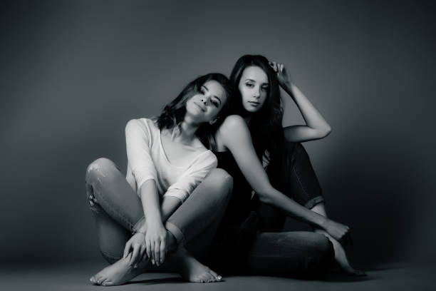 istock Two pretty girls in hipster clothes, sitting 940109090