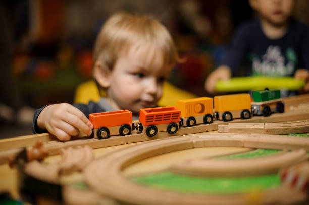 istock Cute little boy playing with toy wooden railway 940118872