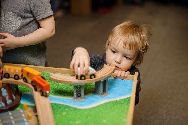 istock Cute little boy is playing with toy wooden train 940119010