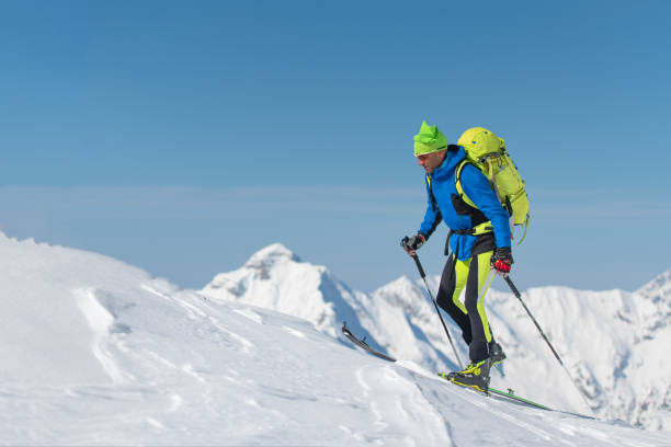 cross country ski seul homme vers la montagne - telemark skiing photos photos et images de collection