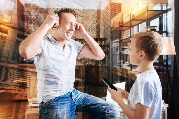 istock Curious boy switching on music while his smiling father wearing headphones 940124102