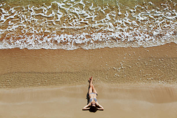 istock Woman sunbathing at the beach 940127552