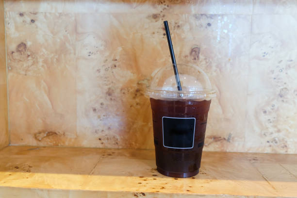 A glass of ice black coffee on wood table