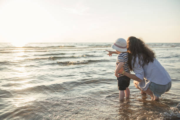 Young woman with little boy on a walk at sunset