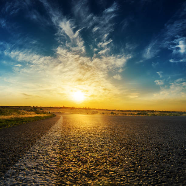 istock asphalt road close up and good orange sunset in clouds 940139738