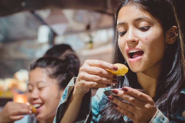 istock Multiethnic female friends eating pani puri. 940142856