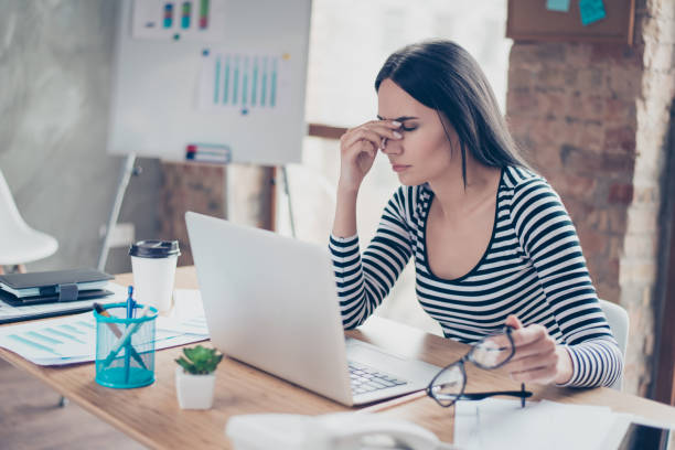 Overworked tired secretary holding spectacles and touching her nose bridge Overworked tired secretary holding spectacles and touching her nose bridge Tensed stock pictures, royalty-free photos & images