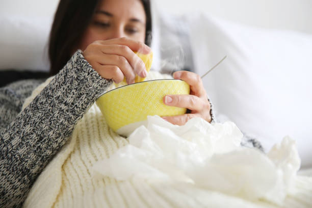 Sick woman drinking soup stock photo