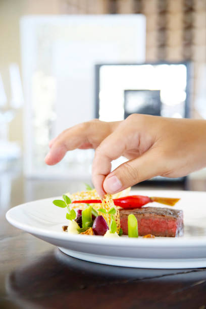 istock Chef decorates very elegant meal on the plate 940156600