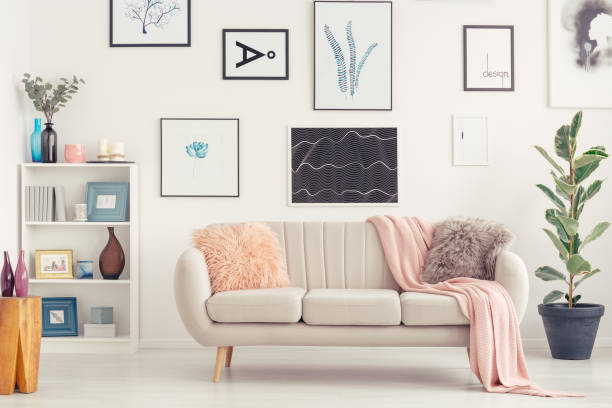 Sofa in living room Elegant sofa, white shelf with decorations and posters on the wall in a living room interior hanging art on wall stock pictures, royalty-free photos & images