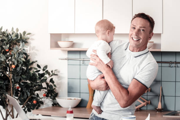 istock Joyful man upbringing his baby 940158474