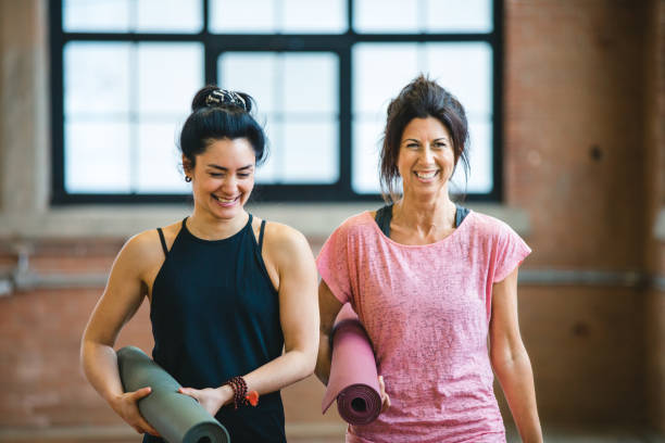 istock Two smiling women getting ready for a yoga class 940159768