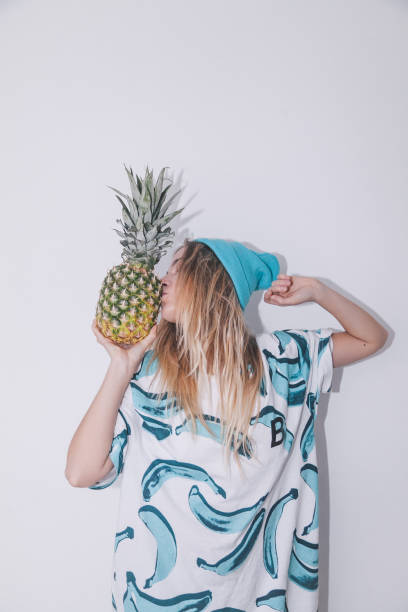 Excited young woman holding pineapple