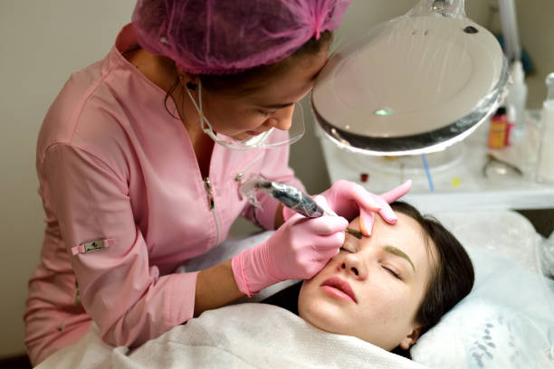 istock beauty Master of permanent tattoo at work 940165800