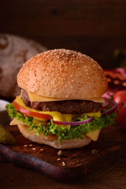 istock Fresh burger closeup. Wooden rustic background. Top view 940167450