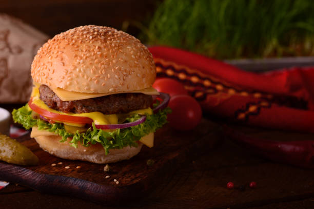 istock Fresh burger closeup. Wooden rustic background. Top view 940167534