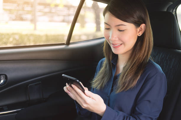 istock Young business woman is using a phone in a car 940167870